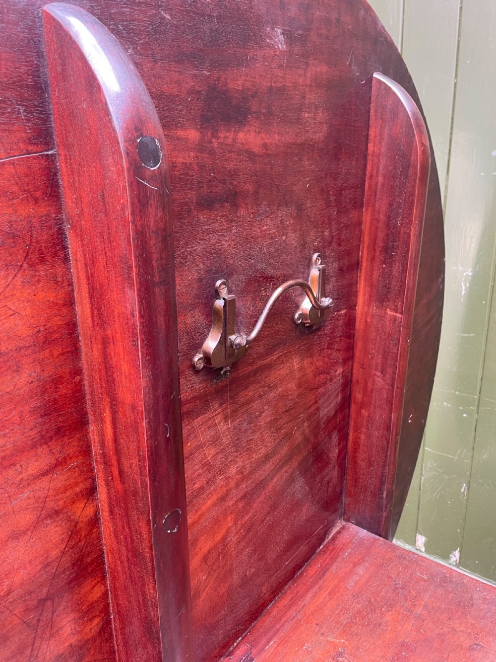 A late George III period circular mahogany tilt-top table shown in a vertical position, featuring a single-piece top and reeded tripod legs with brass castors. View XXV