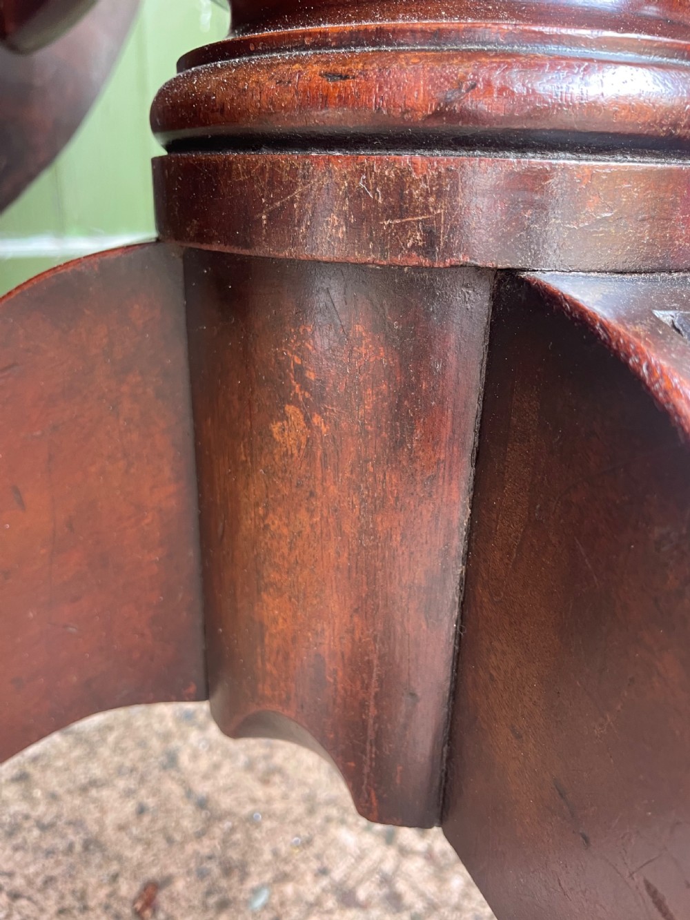 A late George III period circular mahogany tilt-top table shown in a vertical position, featuring a single-piece top and reeded tripod legs with brass castors. View XXVIII