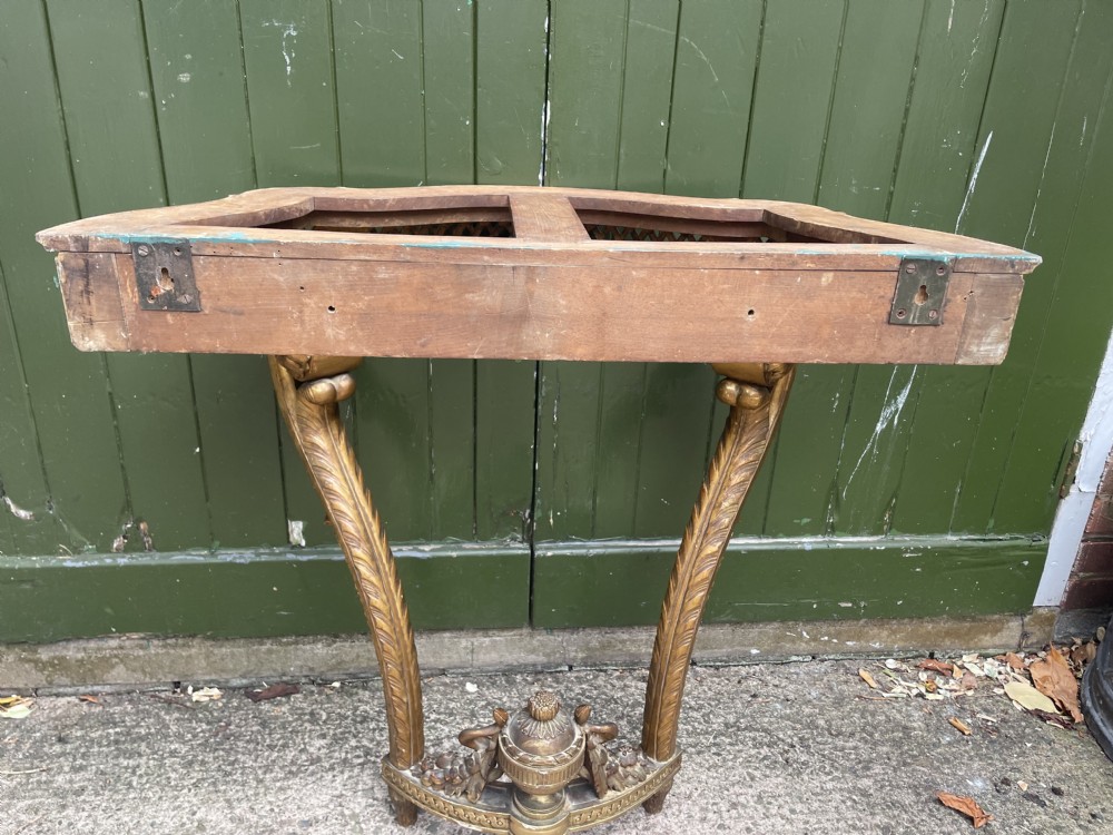A 19th-century French giltwood console table featuring a serpentine variegated marble top, pierced lattice frieze, and carved urn stretcher. View XVIII