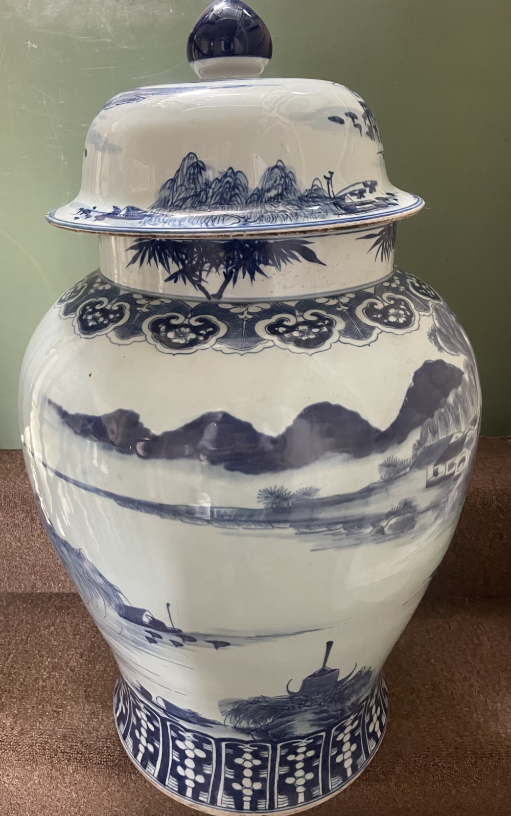 A large Qing dynasty style blue and white porcelain ginger jar with a domed lid decorated with hand-painted traditional Chinese landscape scenes. View II