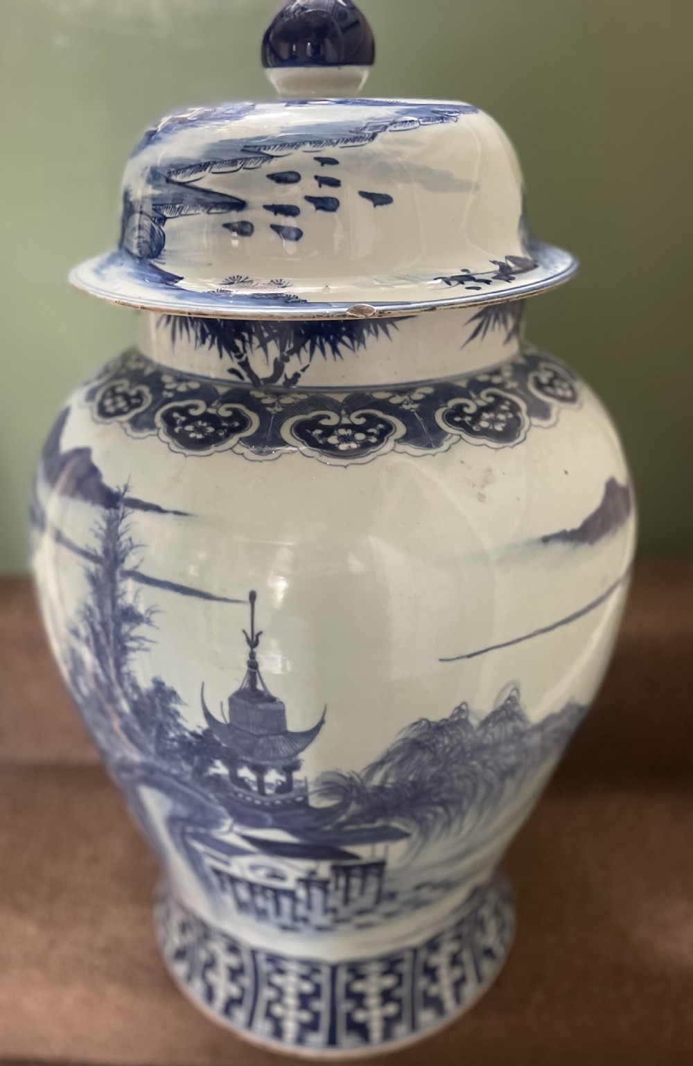 A large Qing dynasty style blue and white porcelain ginger jar with a domed lid decorated with hand-painted traditional Chinese landscape scenes. View IX