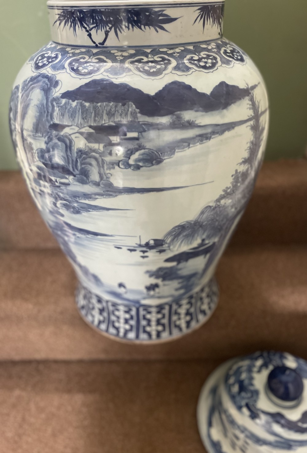 A large Qing dynasty style blue and white porcelain ginger jar with a domed lid decorated with hand-painted traditional Chinese landscape scenes. View XIII
