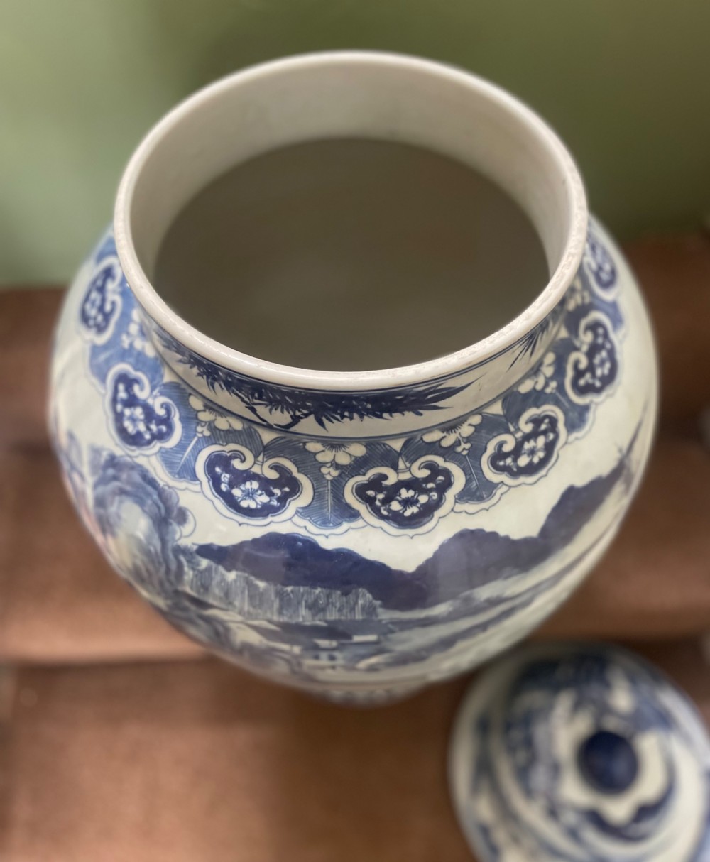 A large Qing dynasty style blue and white porcelain ginger jar with a domed lid decorated with hand-painted traditional Chinese landscape scenes. View XIV