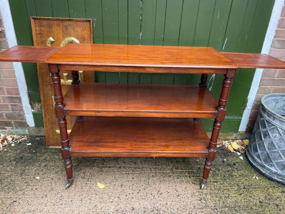 A three-tier George IV mahogany buffet table featuring turned column supports and brass castors. View III