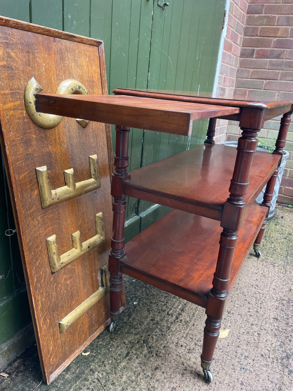 A three-tier George IV mahogany buffet table featuring turned column supports and brass castors. View VI