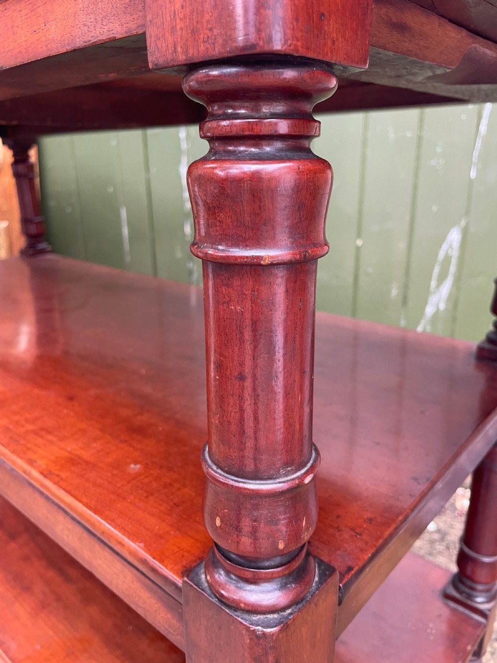 A three-tier George IV mahogany buffet table featuring turned column supports and brass castors. View VII