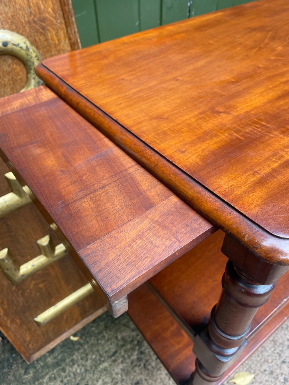 A three-tier George IV mahogany buffet table featuring turned column supports and brass castors. View XI
