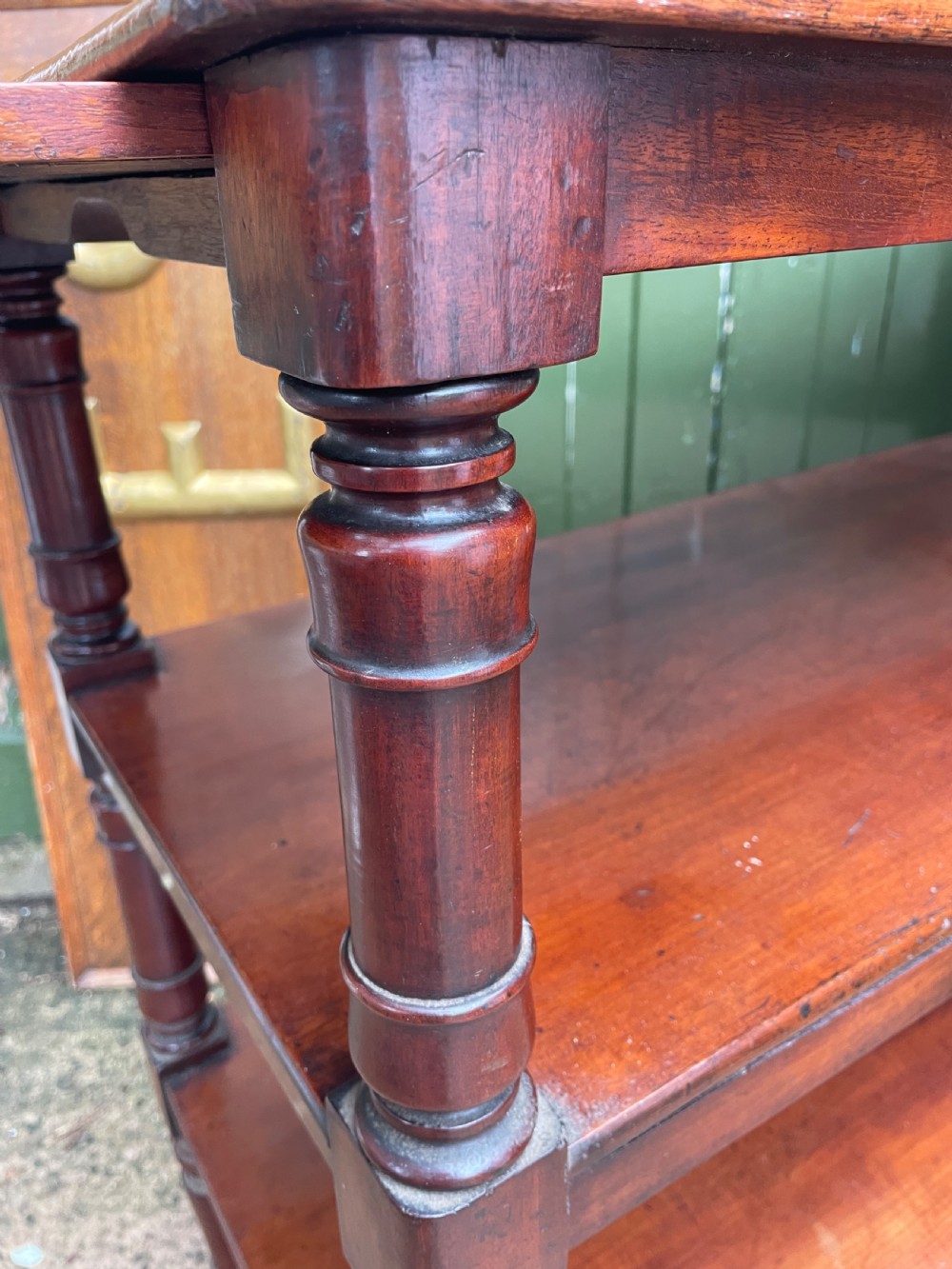 A three-tier George IV mahogany buffet table featuring turned column supports and brass castors. View XIV