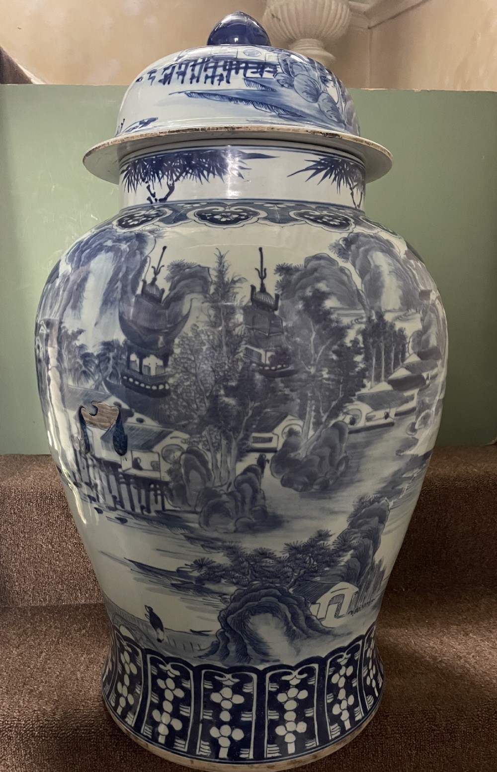 A large Qing dynasty style blue and white porcelain ginger jar with a domed lid decorated with hand-painted traditional Chinese landscape scenes. View XIX