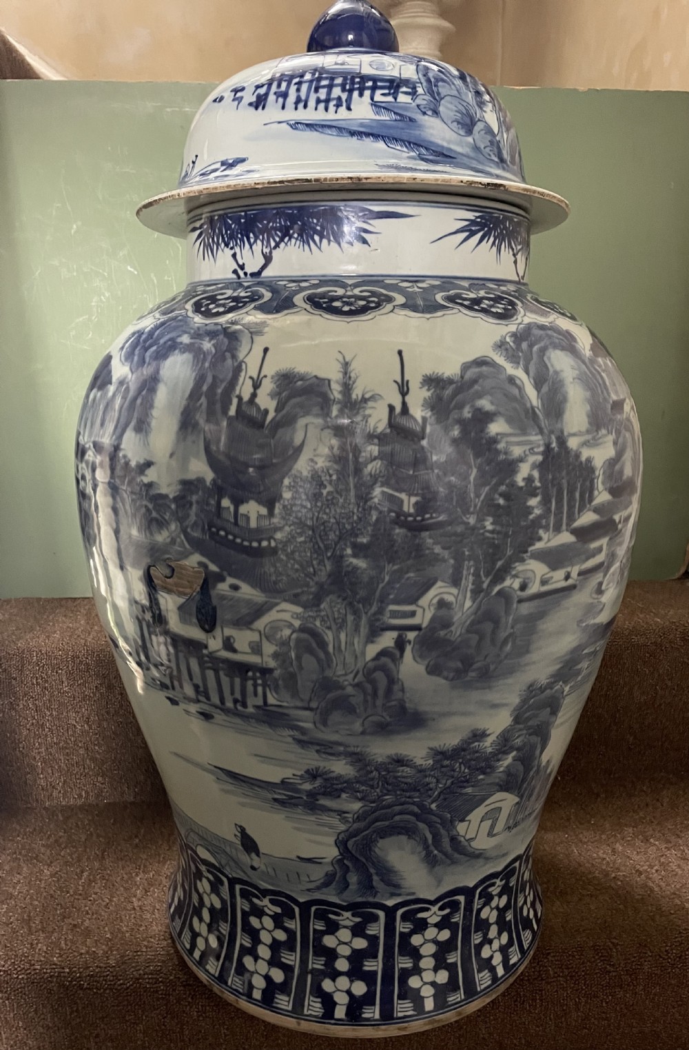 A large Qing dynasty style blue and white porcelain ginger jar with a domed lid decorated with hand-painted traditional Chinese landscape scenes. View XX