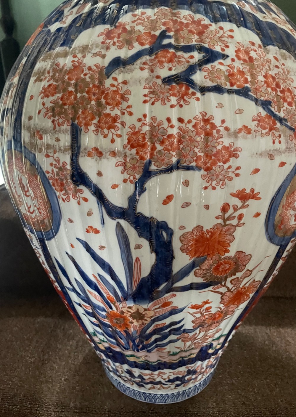 A large Japanese Meiji period porcelain covered vase featuring fluted sides and painted in underglaze blue and iron-red Imari patterns with floral motifs. View V