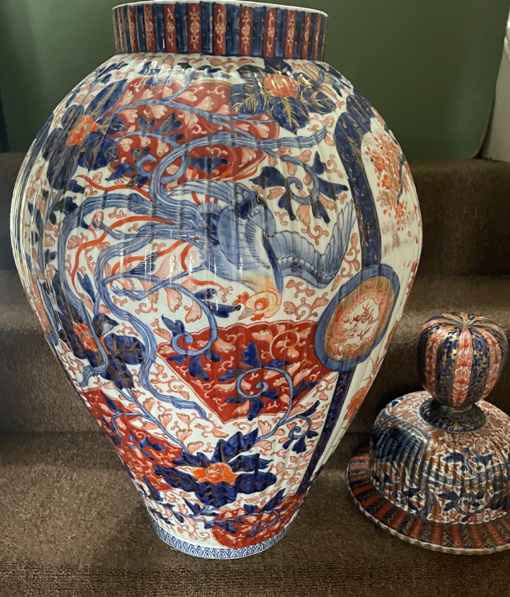 A large Japanese Meiji period porcelain covered vase featuring fluted sides and painted in underglaze blue and iron-red Imari patterns with floral motifs. View VIII