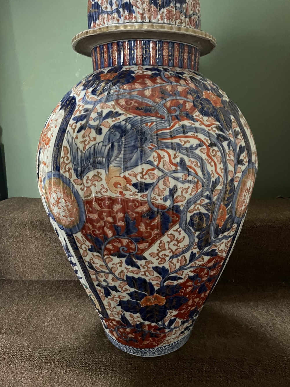 A large Japanese Meiji period porcelain covered vase featuring fluted sides and painted in underglaze blue and iron-red Imari patterns with floral motifs. View XXI