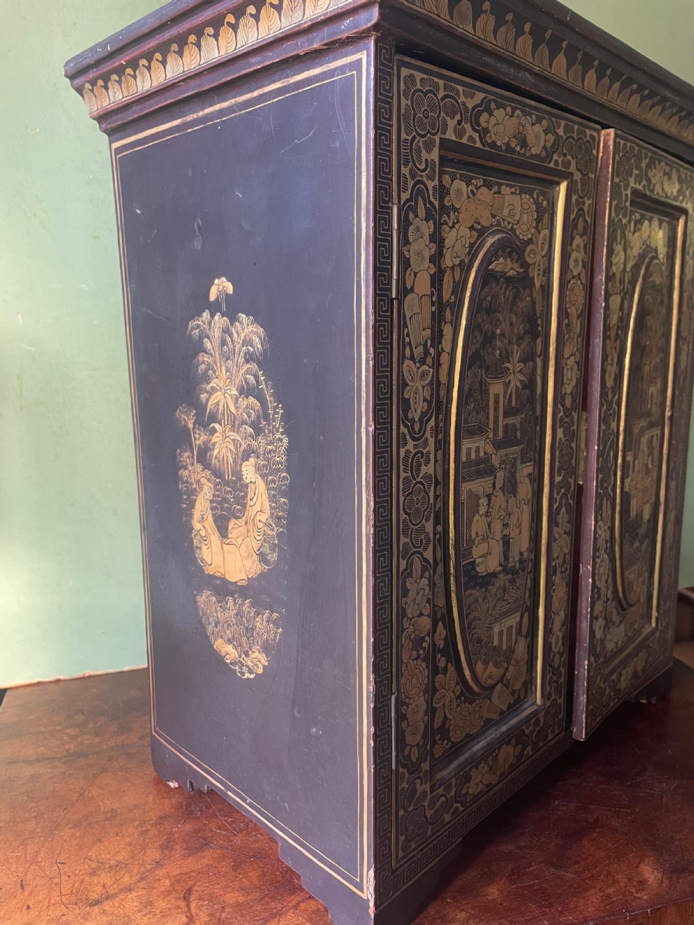 A mid-nineteenth century Chinese export black lacquer table cabinet featuring two doors decorated with gilded figural landscapes, floral borders, and geometric motifs. View III
