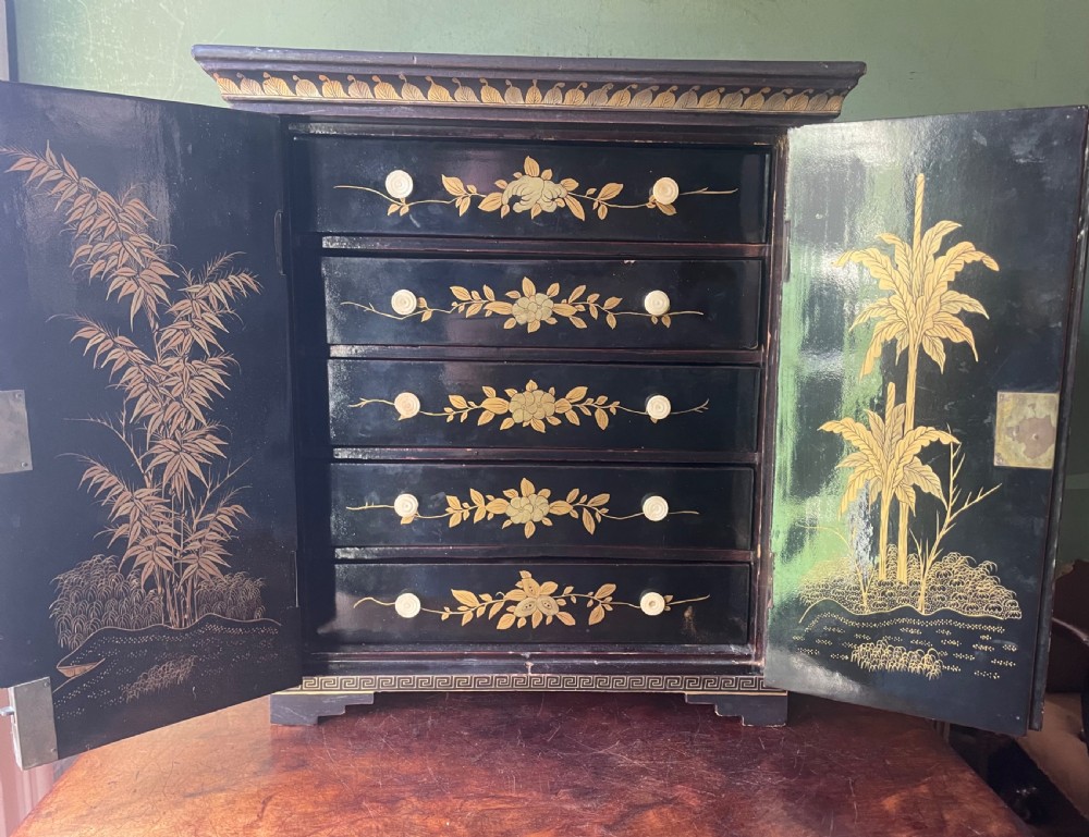 A mid-nineteenth century Chinese export black lacquer table cabinet featuring two doors decorated with gilded figural landscapes, floral borders, and geometric motifs. View IV