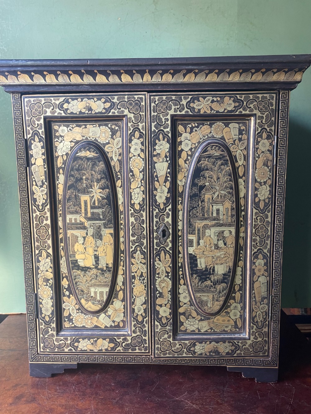 A mid-nineteenth century Chinese export black lacquer table cabinet featuring two doors decorated with gilded figural landscapes, floral borders, and geometric motifs. View XIII