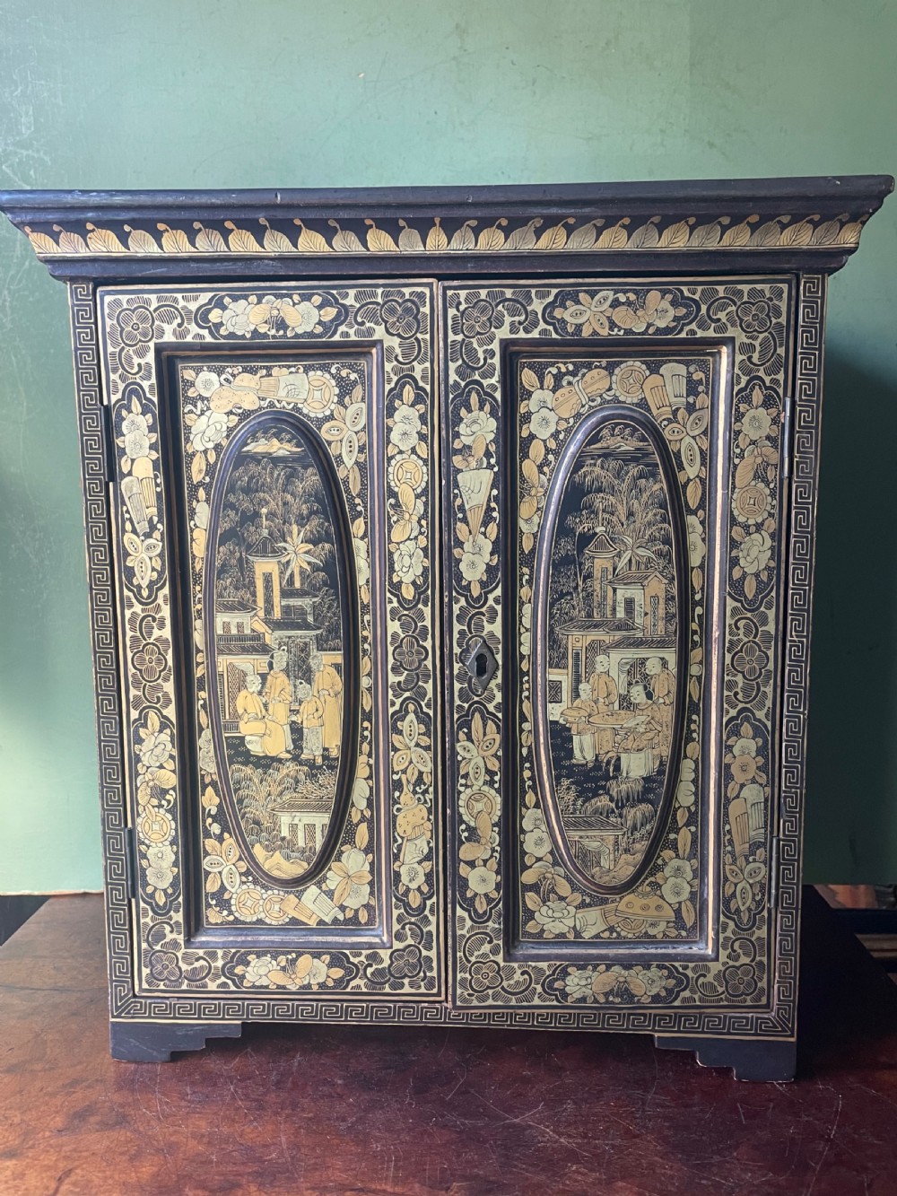 A mid-nineteenth century Chinese export black lacquer table cabinet featuring two doors decorated with gilded figural landscapes, floral borders, and geometric motifs. View XIV
