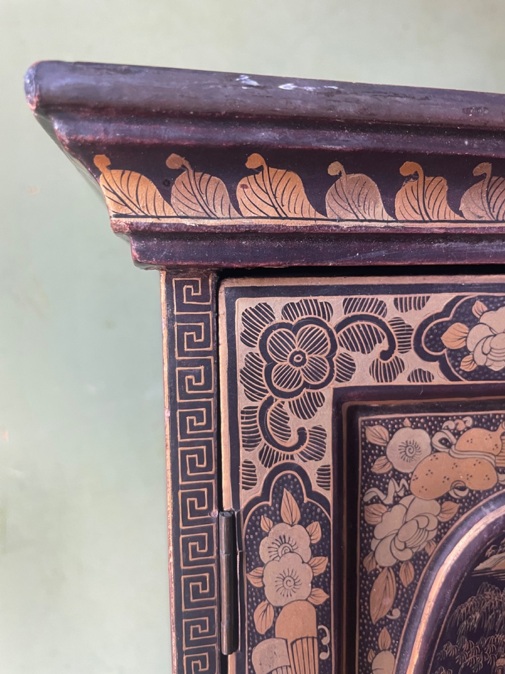 A mid-nineteenth century Chinese export black lacquer table cabinet featuring two doors decorated with gilded figural landscapes, floral borders, and geometric motifs. View XVI