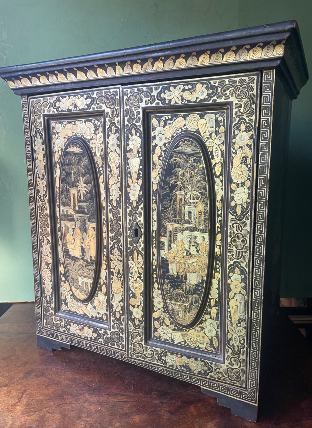 A mid-nineteenth century Chinese export black lacquer table cabinet featuring two doors decorated with gilded figural landscapes, floral borders, and geometric motifs. View XVII