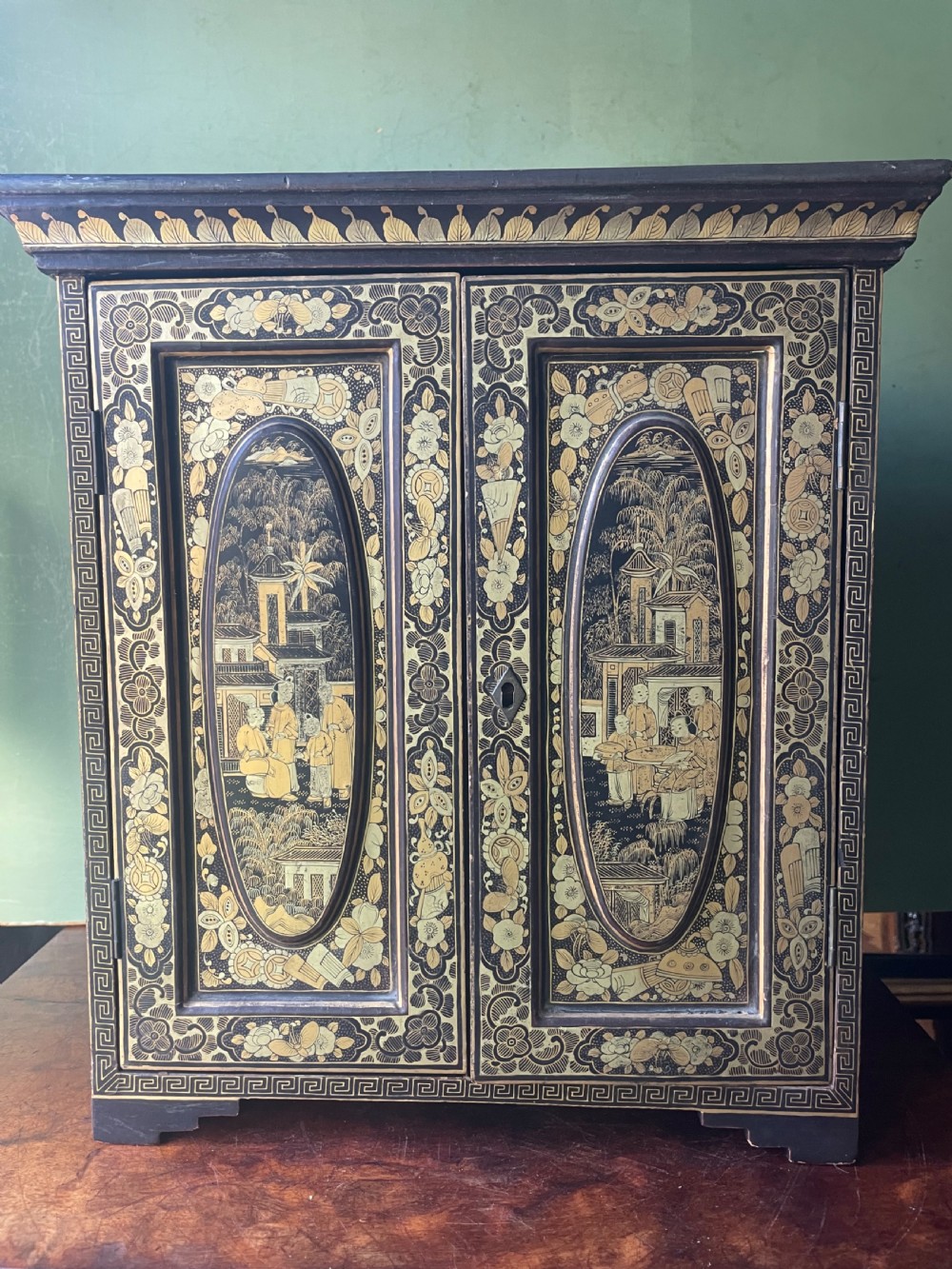 A mid-nineteenth century Chinese export black lacquer table cabinet featuring two doors decorated with gilded figural landscapes, floral borders, and geometric motifs. View XXI