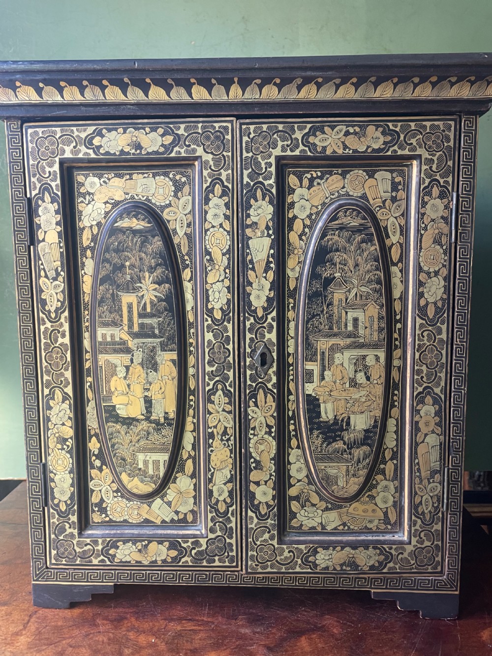 A mid-nineteenth century Chinese export black lacquer table cabinet featuring two doors decorated with gilded figural landscapes, floral borders, and geometric motifs. View XXII