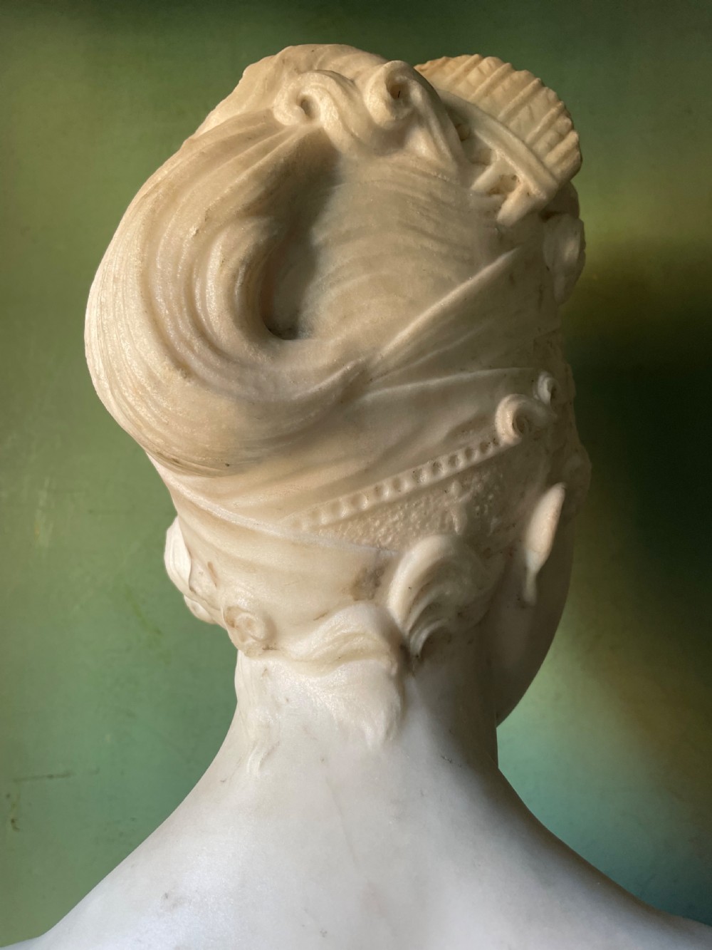 A late nineteenth-century carved white statuary marble portrait bust depicting a female figure with draped cloth held across her chest and stylized hair. View IX