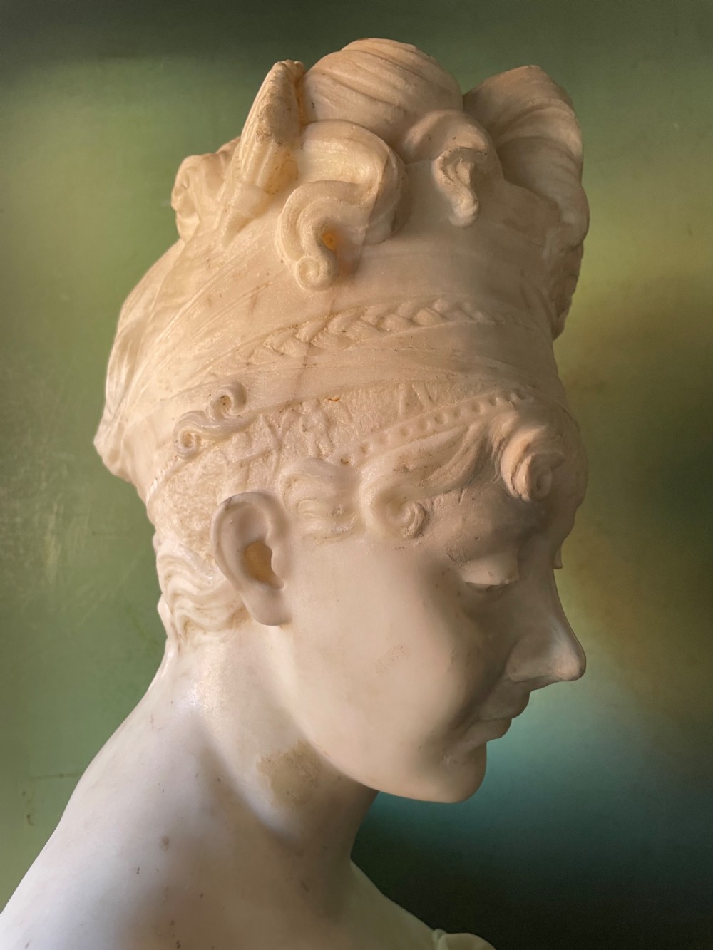 A late nineteenth-century carved white statuary marble portrait bust depicting a female figure with draped cloth held across her chest and stylized hair. View XIII