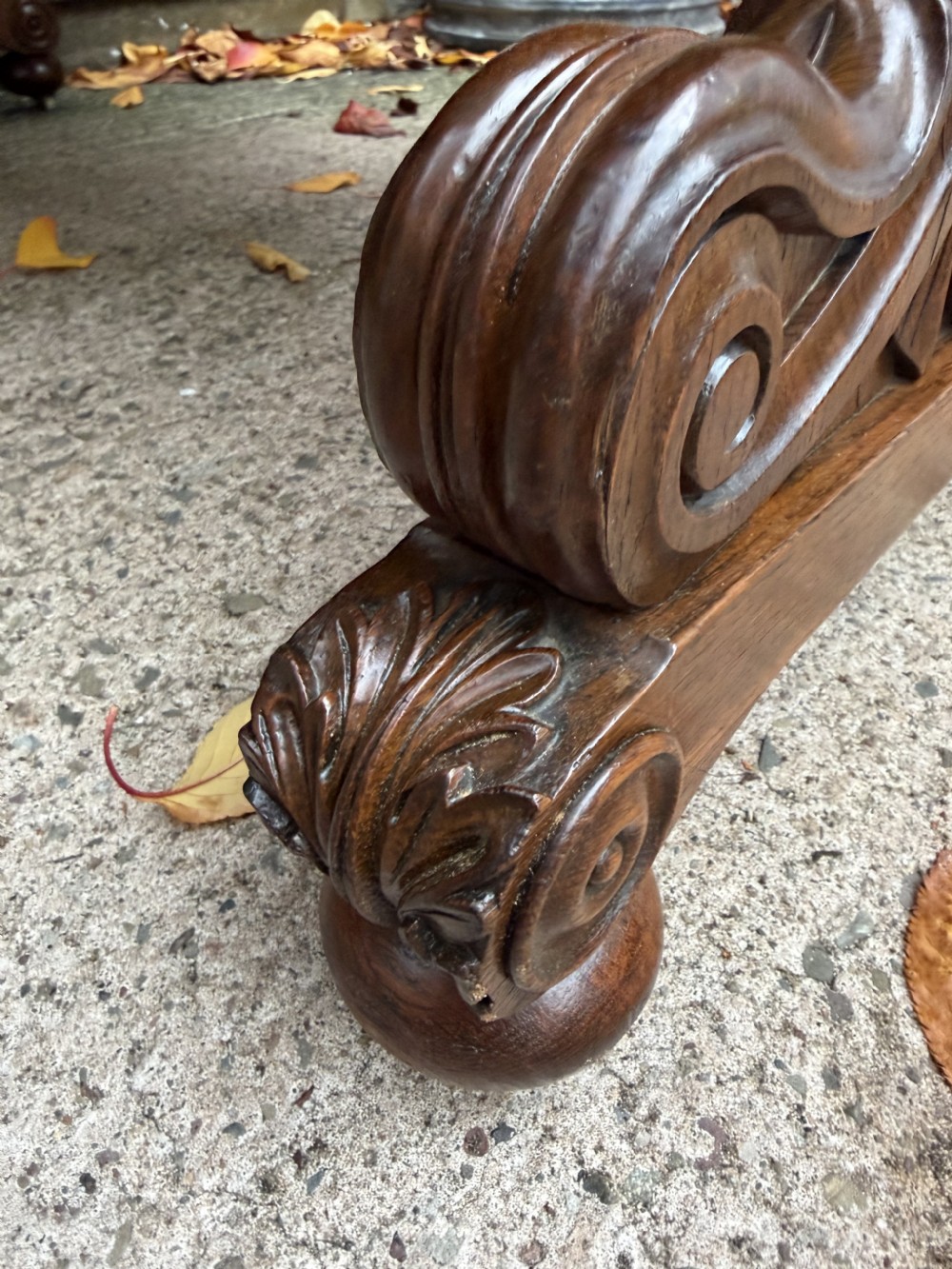 An early 19th-century William IV oak library table featuring a central carved acorn frieze panel, scrolled trestle supports, and a turned stretcher base. View X