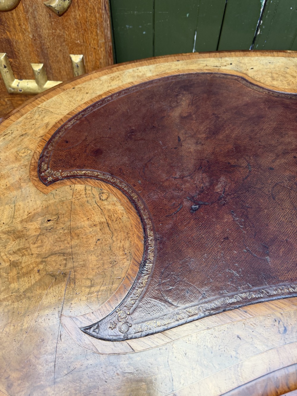 A mid-19th-century kidney-shaped burr walnut writing table with an inset leather surface and cast ormolu mounts on cabriole legs. View X