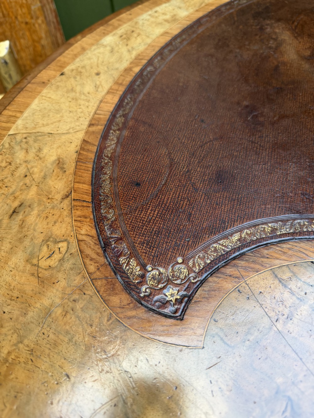A mid-19th-century kidney-shaped burr walnut writing table with an inset leather surface and cast ormolu mounts on cabriole legs. View XII