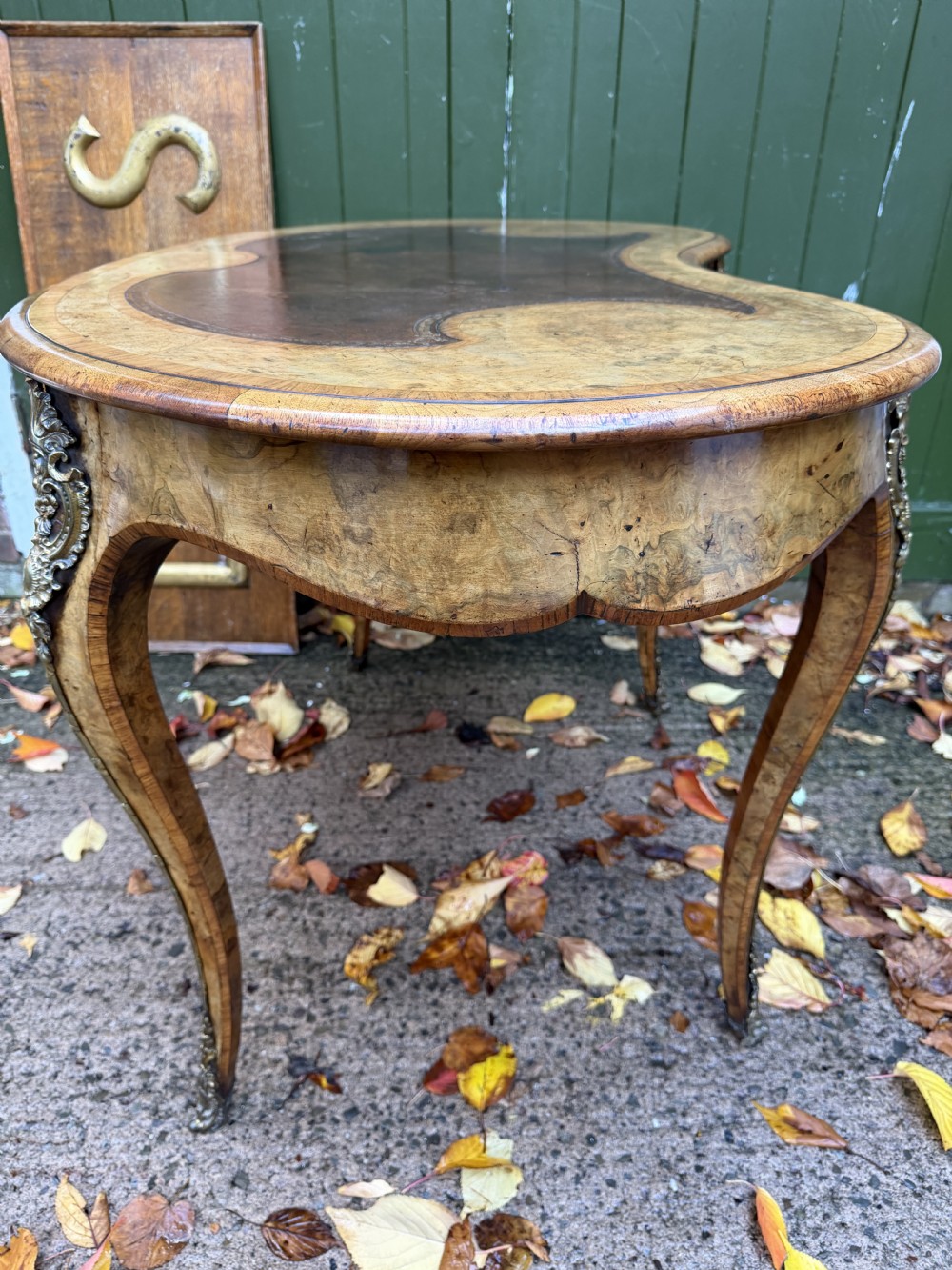 A mid-19th-century kidney-shaped burr walnut writing table with an inset leather surface and cast ormolu mounts on cabriole legs. View XIII