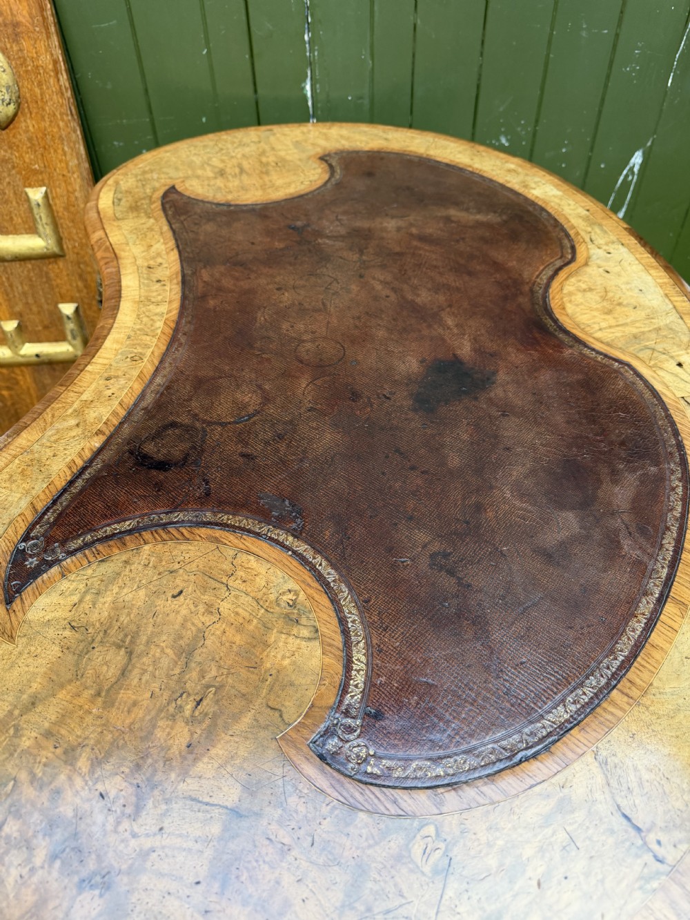 A mid-19th-century kidney-shaped burr walnut writing table with an inset leather surface and cast ormolu mounts on cabriole legs. View XVI