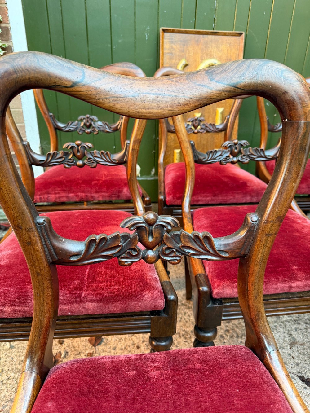 A set of eight early 19th-century William IV rosewood dining chairs with carved back rails, fluted front legs, and red velvet seats. View III