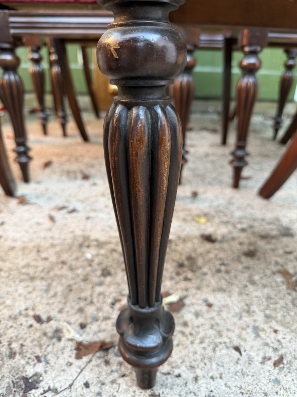 A set of eight early 19th-century William IV rosewood dining chairs with carved back rails, fluted front legs, and red velvet seats. View V