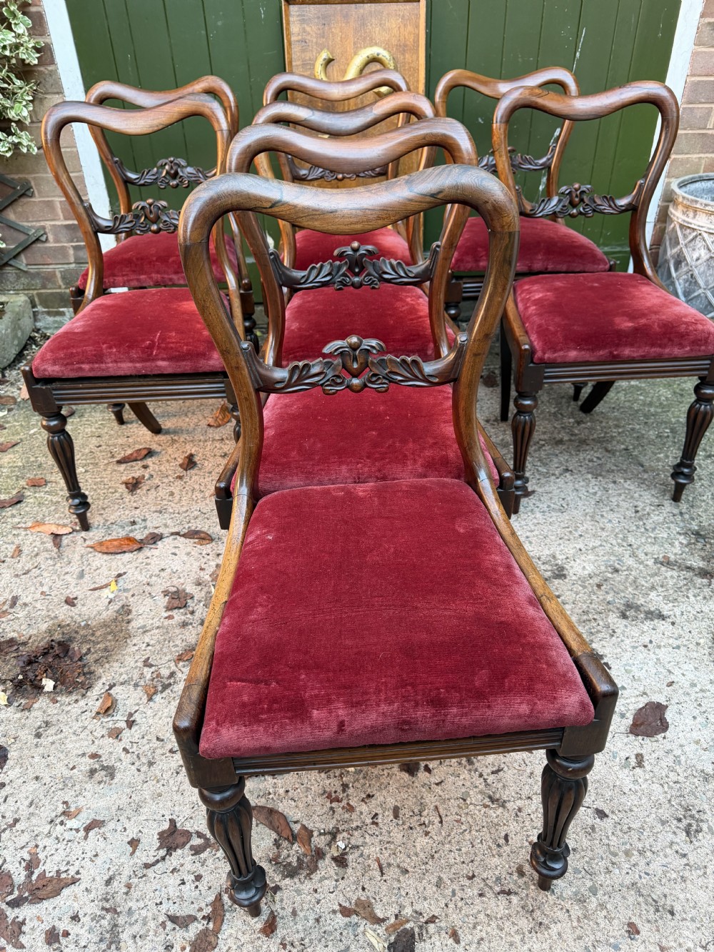 A set of eight early 19th-century William IV rosewood dining chairs with carved back rails, fluted front legs, and red velvet seats. View XI