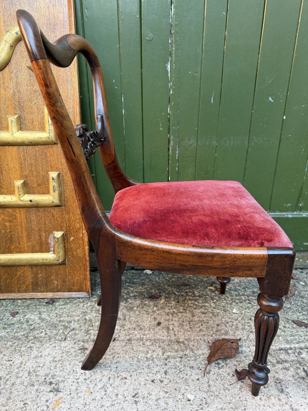 A set of eight early 19th-century William IV rosewood dining chairs with carved back rails, fluted front legs, and red velvet seats. View XVI