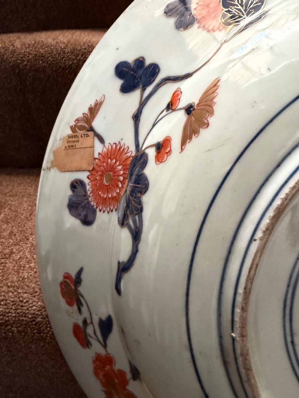 A circular Japanese Imari porcelain dished charger decorated in cobalt blue, iron-red, green, and gold with central chrysanthemum and floral panel designs. View VI