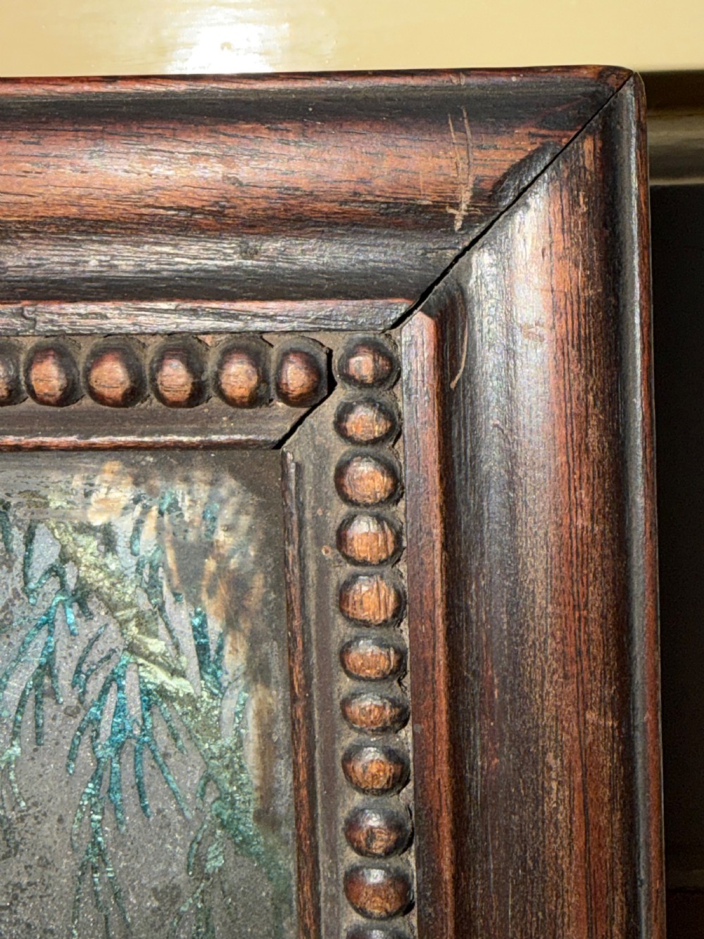 An early nineteenth-century Chinese export reverse glass picture featuring a figure on a boat against a silvered mirror background, encased in a dark wooden frame with beaded inner moulding. View V