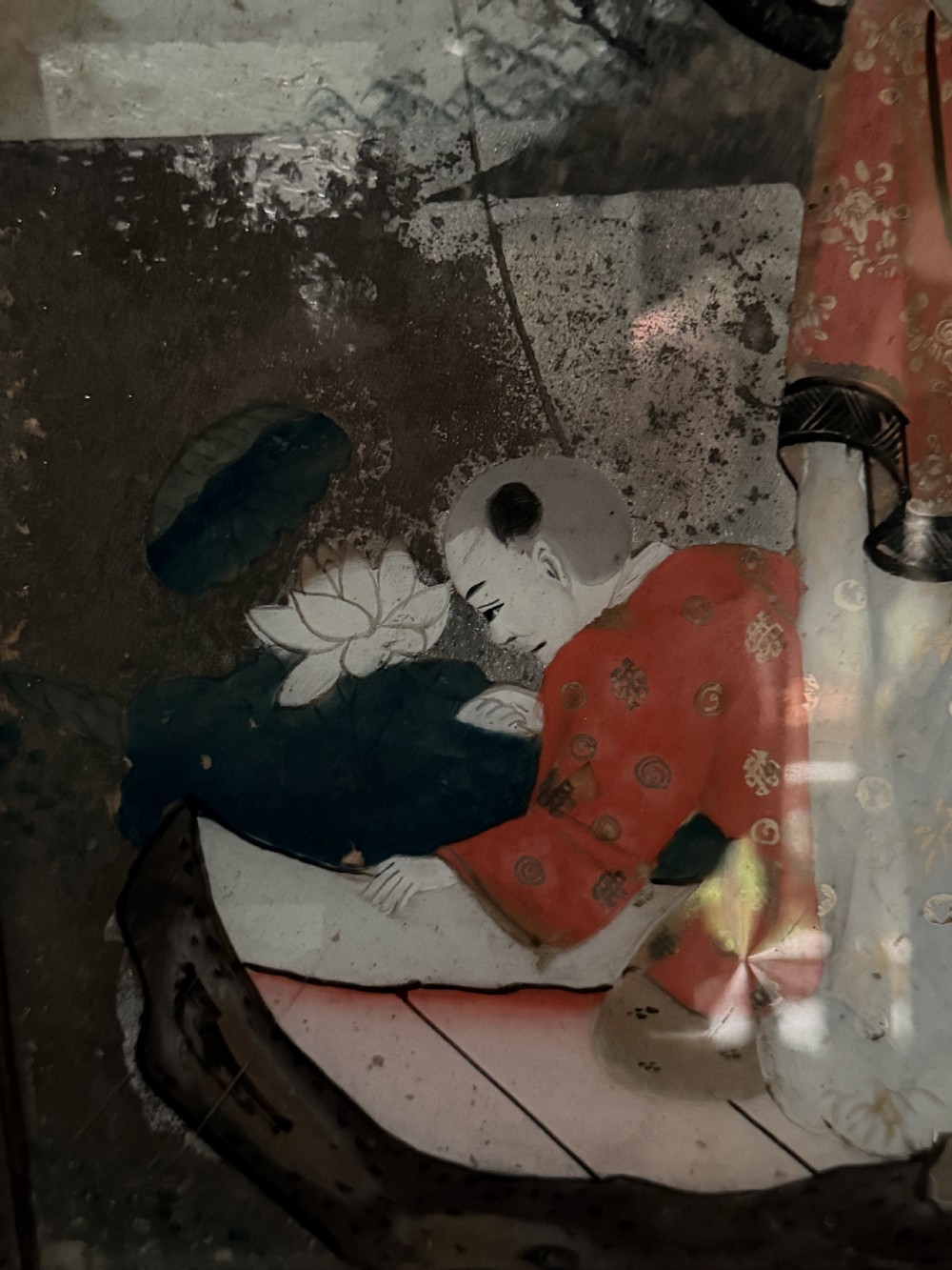 An early nineteenth-century Chinese export reverse glass picture featuring a figure on a boat against a silvered mirror background, encased in a dark wooden frame with beaded inner moulding. View VIII