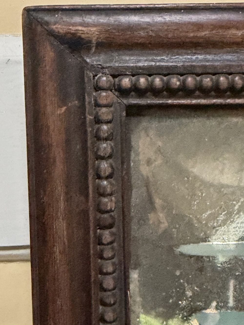 An early nineteenth-century Chinese export reverse glass picture featuring a figure on a boat against a silvered mirror background, encased in a dark wooden frame with beaded inner moulding. View XI