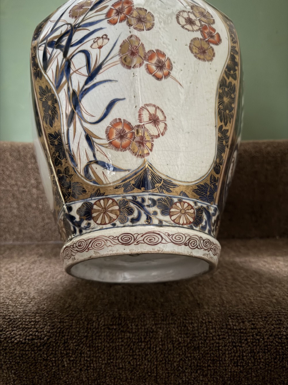 A three-piece Japanese Imari porcelain garniture featuring a central octagonal baluster jar flanked by two trumpet-shaped beaker vases, decorated with floral panels in cobalt blue, iron red, and gold. View XV