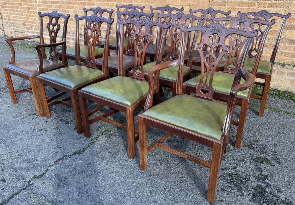 A set of twelve late nineteenth-century mahogany dining chairs featuring carved pierced back splats and green leather seats. View XV