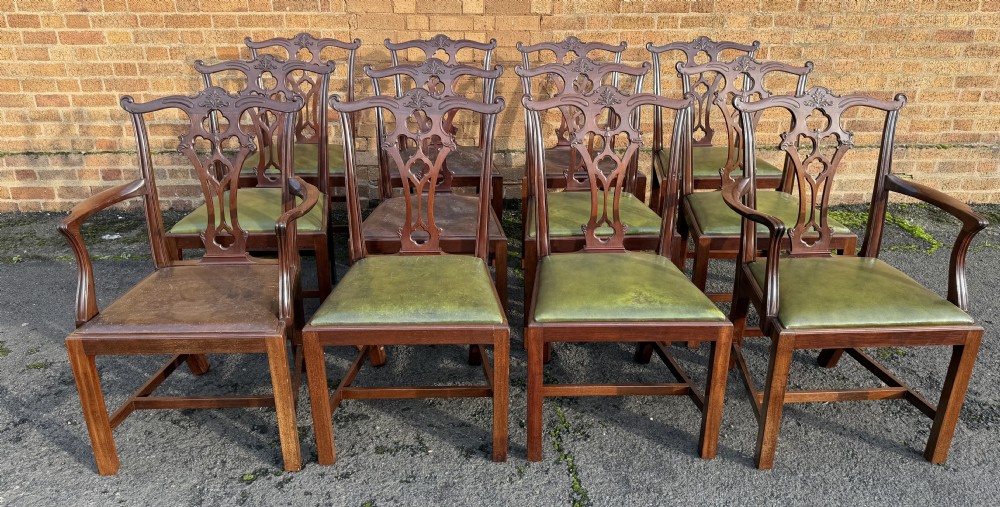 A set of twelve late nineteenth-century mahogany dining chairs featuring carved pierced back splats and green leather seats. View XX