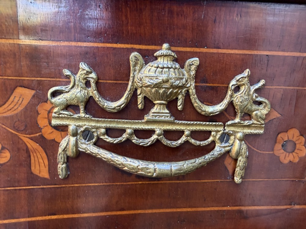 An antique Dutch walnut bureau with floral marquetry inlays, a curved cylinder front, three drawers, and decorative brass handles. View VII