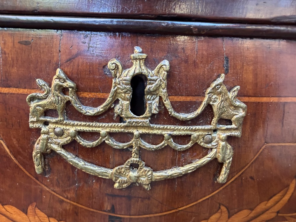 An antique Dutch walnut bureau with floral marquetry inlays, a curved cylinder front, three drawers, and decorative brass handles. View VIII