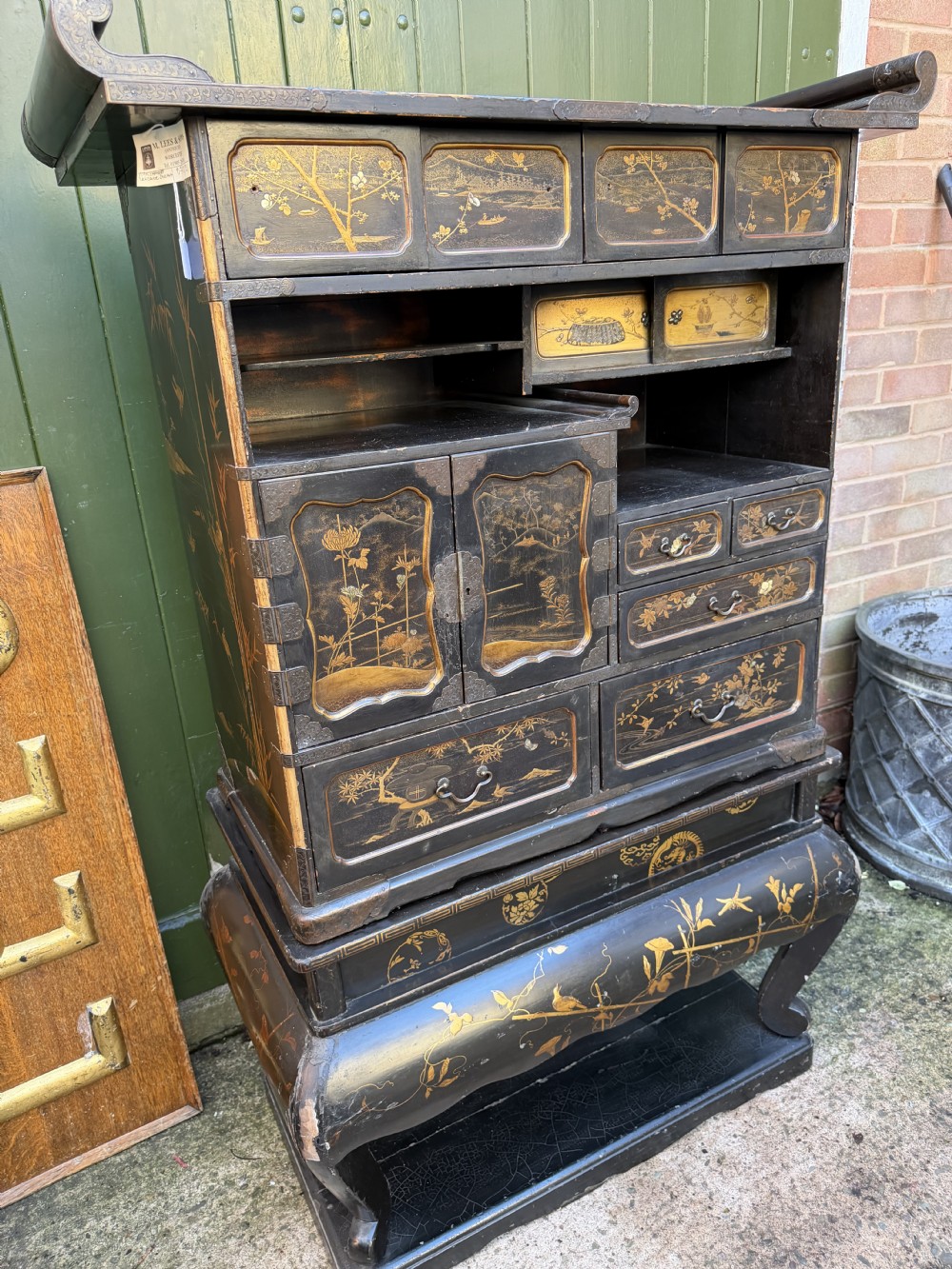 Late nineteenth-century Japanese Meiji period black lacquer shodana cabinet-on-stand with gold maki-e pictorial panels, asymmetrical shelves, and engraved metal fitments. View III