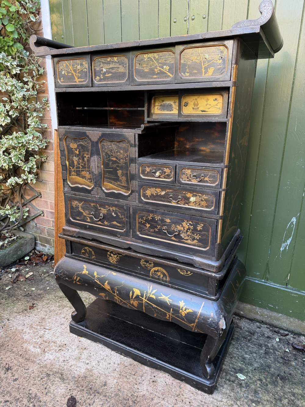 Late nineteenth-century Japanese Meiji period black lacquer shodana cabinet-on-stand with gold maki-e pictorial panels, asymmetrical shelves, and engraved metal fitments. View VI