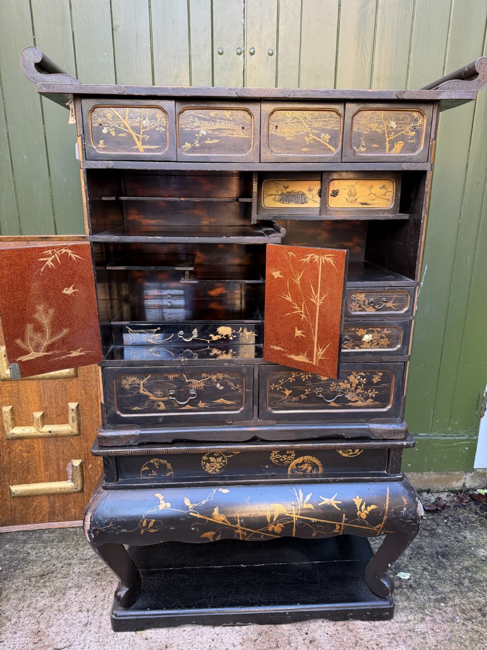 Late nineteenth-century Japanese Meiji period black lacquer shodana cabinet-on-stand with gold maki-e pictorial panels, asymmetrical shelves, and engraved metal fitments. View XI