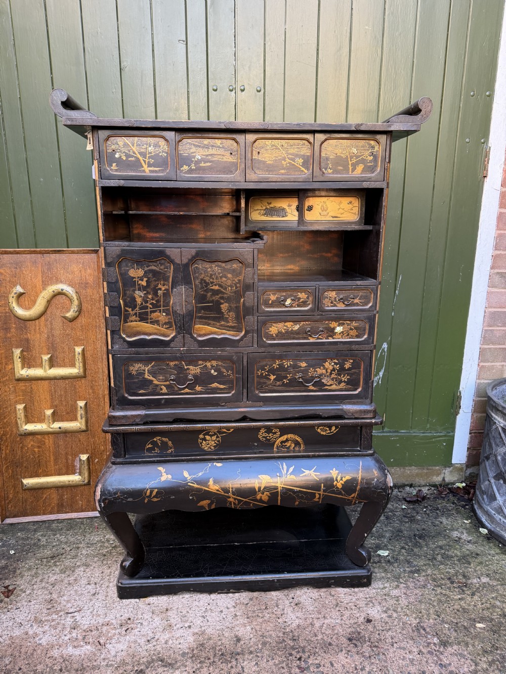 Late nineteenth-century Japanese Meiji period black lacquer shodana cabinet-on-stand with gold maki-e pictorial panels, asymmetrical shelves, and engraved metal fitments. View XXIII
