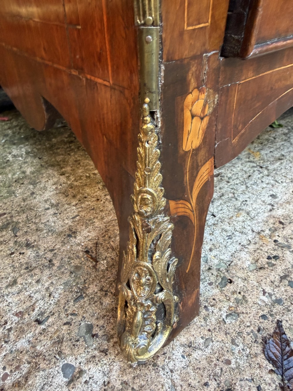 An antique Dutch walnut bureau with floral marquetry inlays, a curved cylinder front, three drawers, and decorative brass handles. View XIII